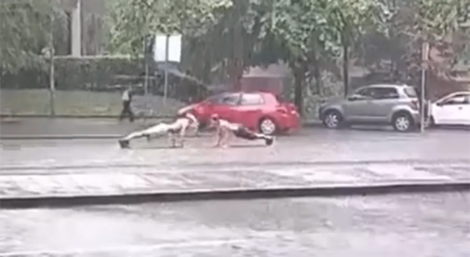 Kiša "potapa" grad, dvojac na ulici radi sklekove - VIDEO