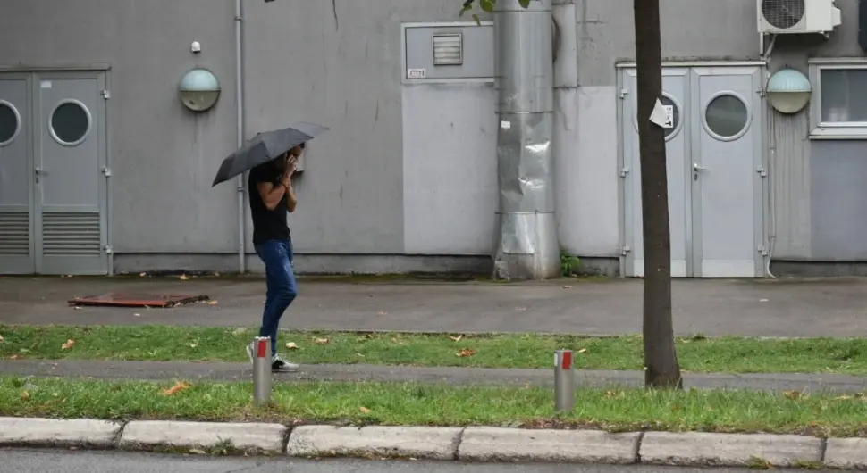 Kišni dan u gradu, mokra saobraćajnica, kapljice kiše i prolaznici sa kišobranima stvaraju autentičnu atmosferu jesenje svakodnevice. Savršena ilustracija za teme poput vremena, gradske svakodnevice i urbane fotografije.