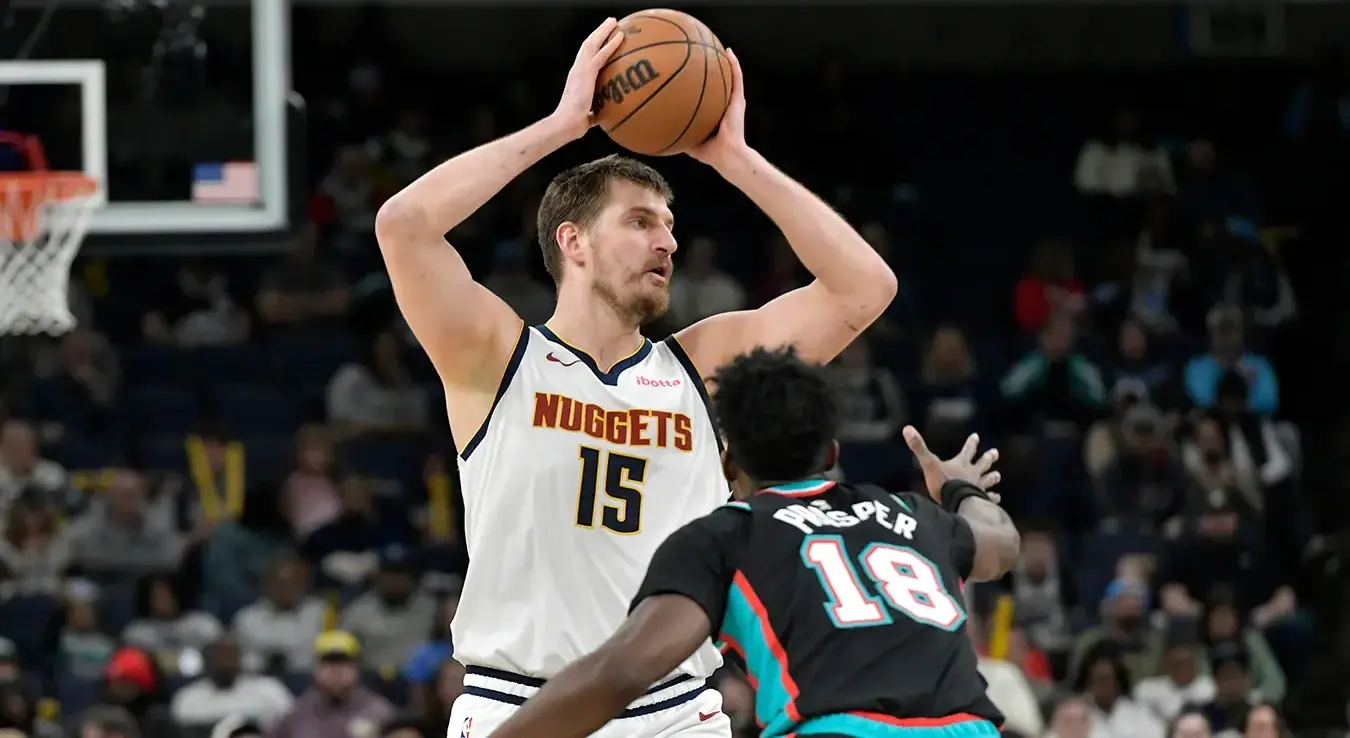 Центар Денвер Нагетса Никола Јокић  додаје лопту нападачу Мемфис Гризлиса Оливије-Максенсу Просперу у првом полувремену НБА кошаркашке утакмице.