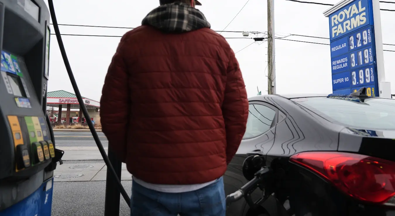 Особа пуни свој аутомобил горивом док су цијене горива на бензинској пумпи истакнуте иза ње, сриједа, 4. март 2026. године, у Балтимору.