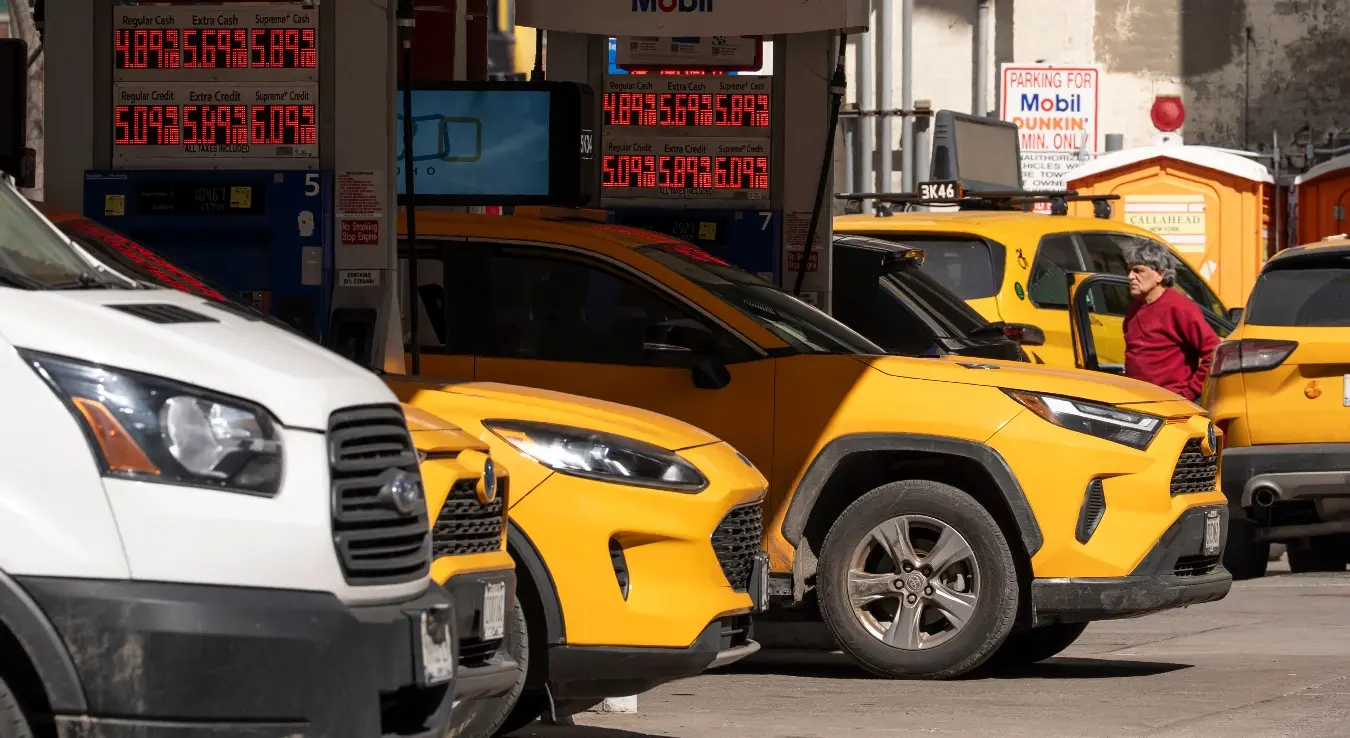 Гужва на бензинској пумпи. Више возача чека да наточи гориво, док се на табли виде цијене горива.