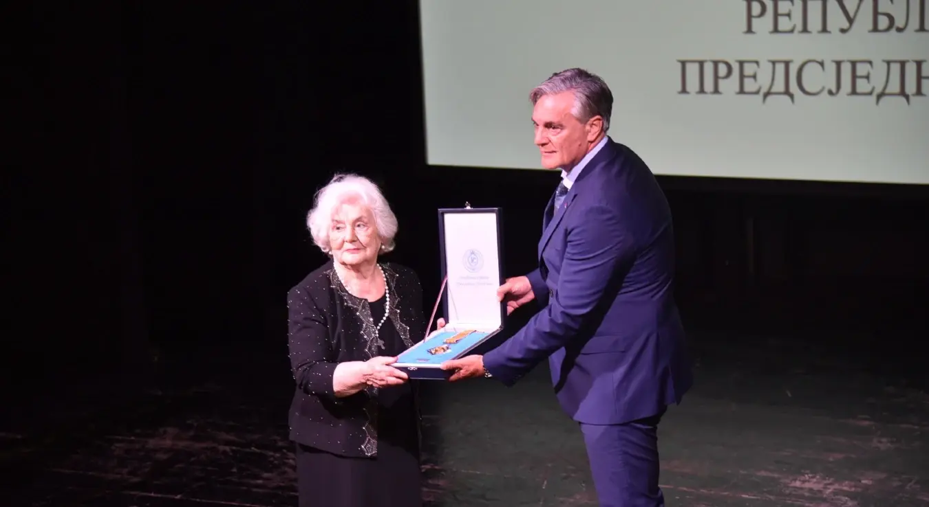 Предсједник Републике Српске Синиша Каран уручује одликовање Јелени Бухач Радојчић, свједоку голготе и преживјелој хероини концентрационог логора Јасеновац.
