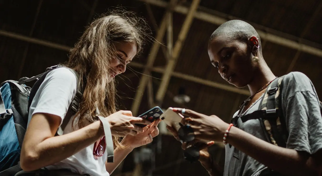 Двије дјевојке одговарају проводе вријеме на телефону