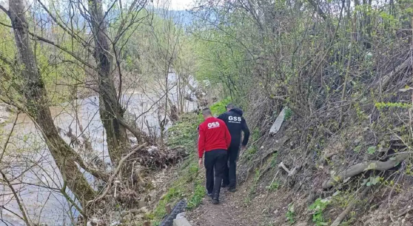 Два припадника Горске службе спасавања Нови Град један у црвеној, други у црној униформи пролазе кроз шуму