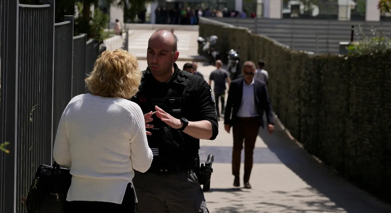 Полицајац разговара са женом испред зграде суда након што је наоружани нападач отворио ватру и повредио неколико људи у Атини, у уторак, 28. априла 2026. године.