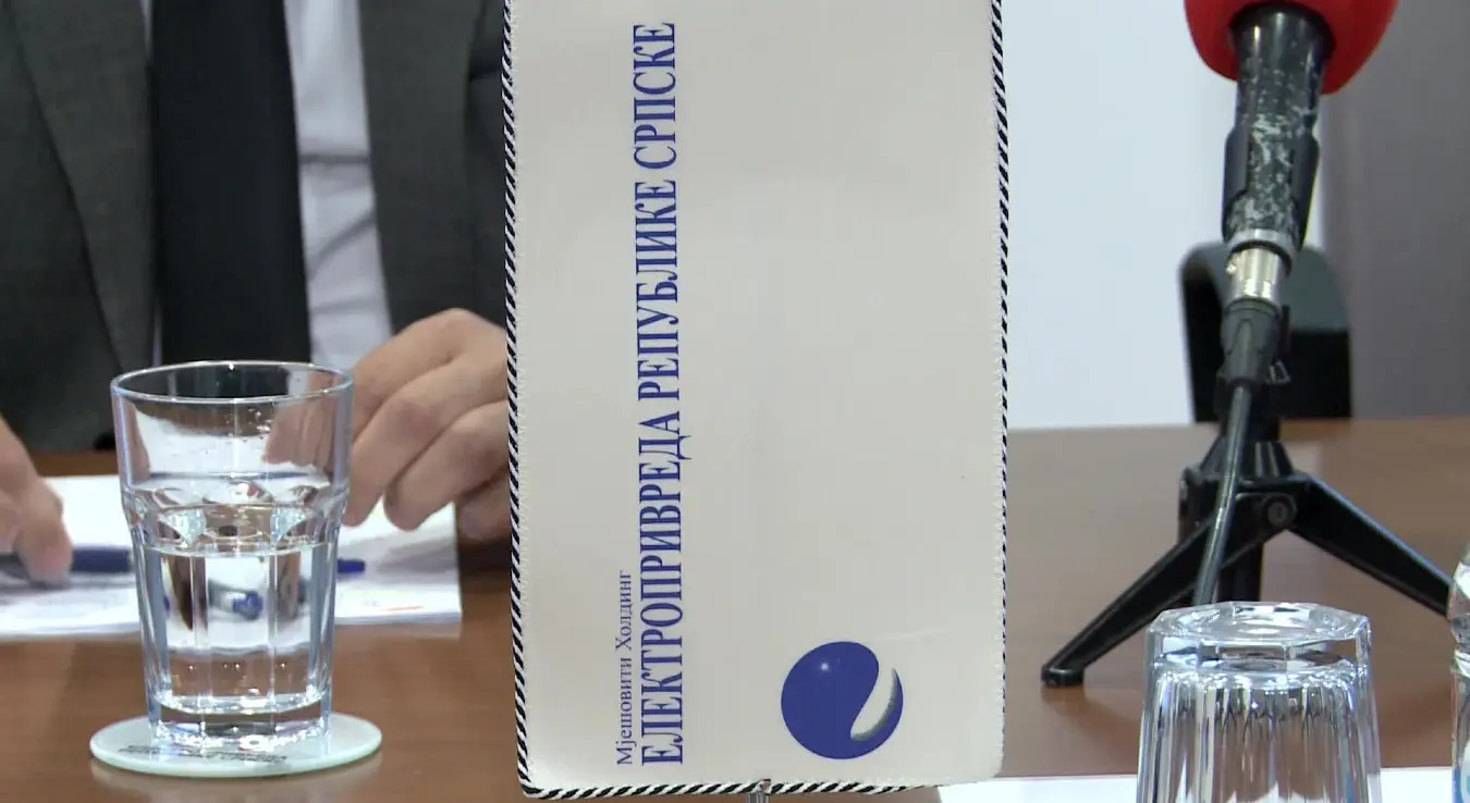 Заставица са логом и натписом Електропривреда Републике Српске, постављена на столу поред микрофона АТВ-а.