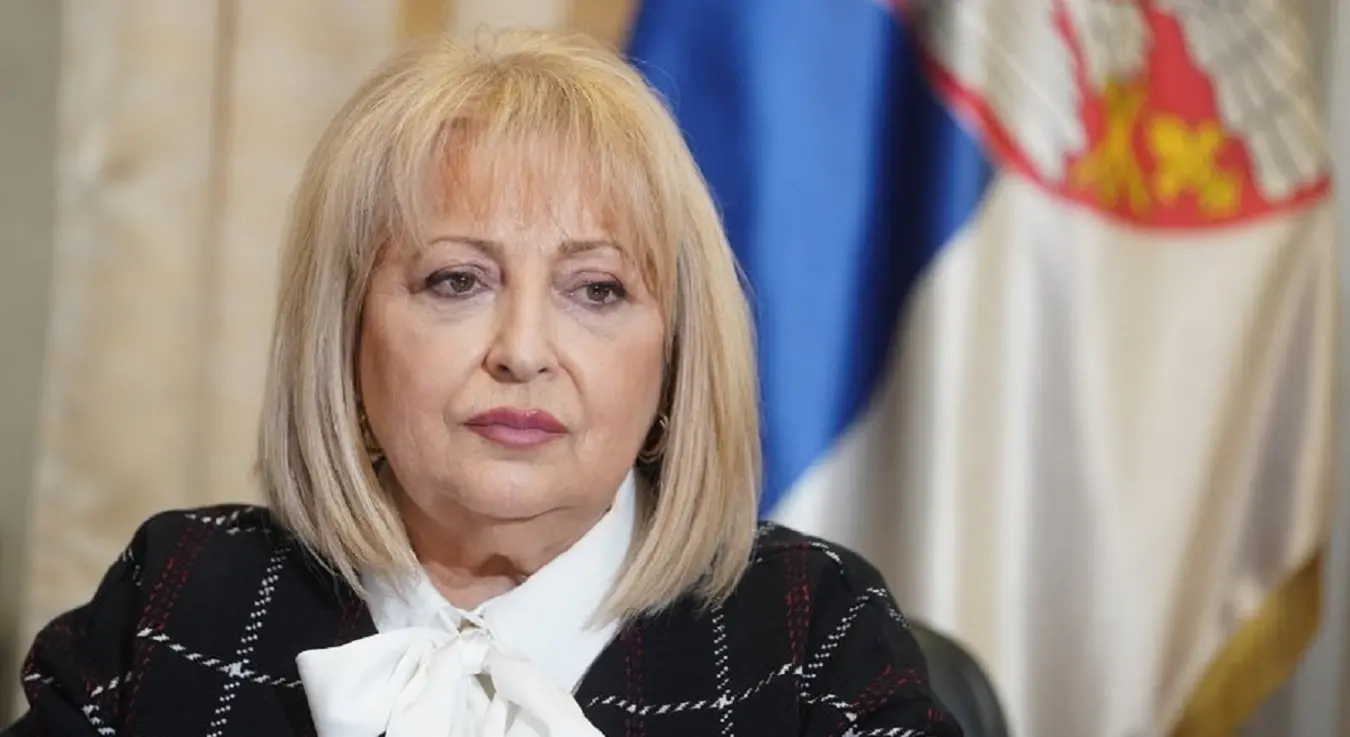 Политичарка Славица Ђукић Дејановић позира испред заставе Србије