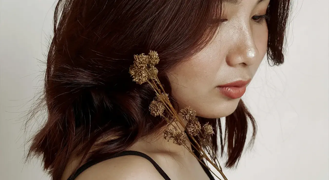 Дјевојка са смеђом косом држи цвијеће у руци.