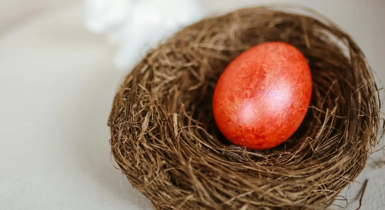 Офарбано црвено јаје у плетеној кошарици