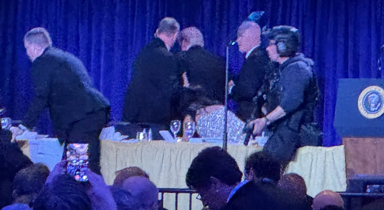 Агенти америчке Тајне службе окружују предсједника Доналда Трампа, трећег с лева, док га своде са бине након пуцњаве испред балске сале током вечере дописника Бијеле куће, у суботу, 25. априла 2026. године, у Вашингтону.