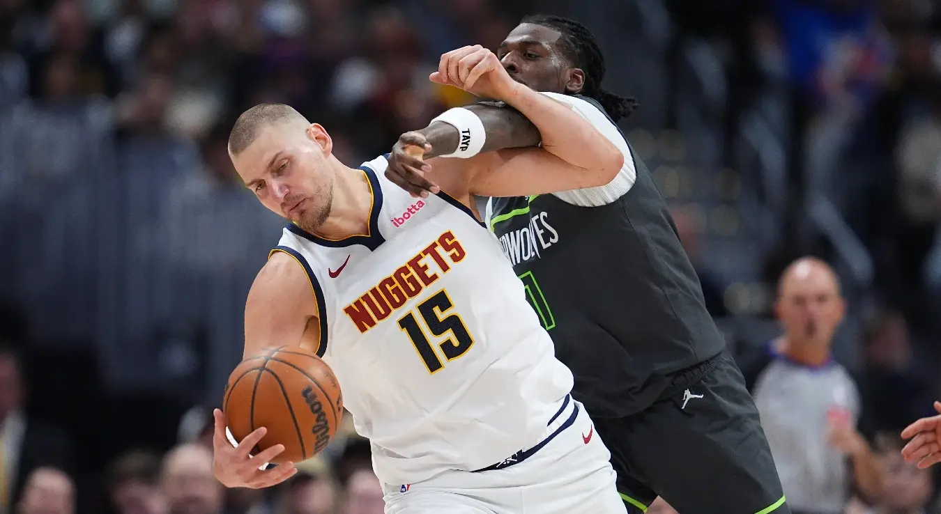 Центар Минесота Тимбервулвса, Наз Рид, десно, добија фаул док центар Денвер Нагетса, Никола Јокић, шаље лопту у другом полувремену прве утакмице плеј-офа НБА лиге, у суботу, 18. априла 2026. године, у Денверу.