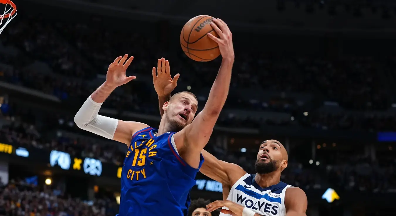 Центар Денвер Нагетса Никола Јокић (15) хвата лопту од центра Минесота Тимбервулвса Рудија Гобера (27) током другог полувремена друге утакмице прве рунде плеј-офа НБА лиге у понедељак, 20. априла 2026. године, у Денверу.