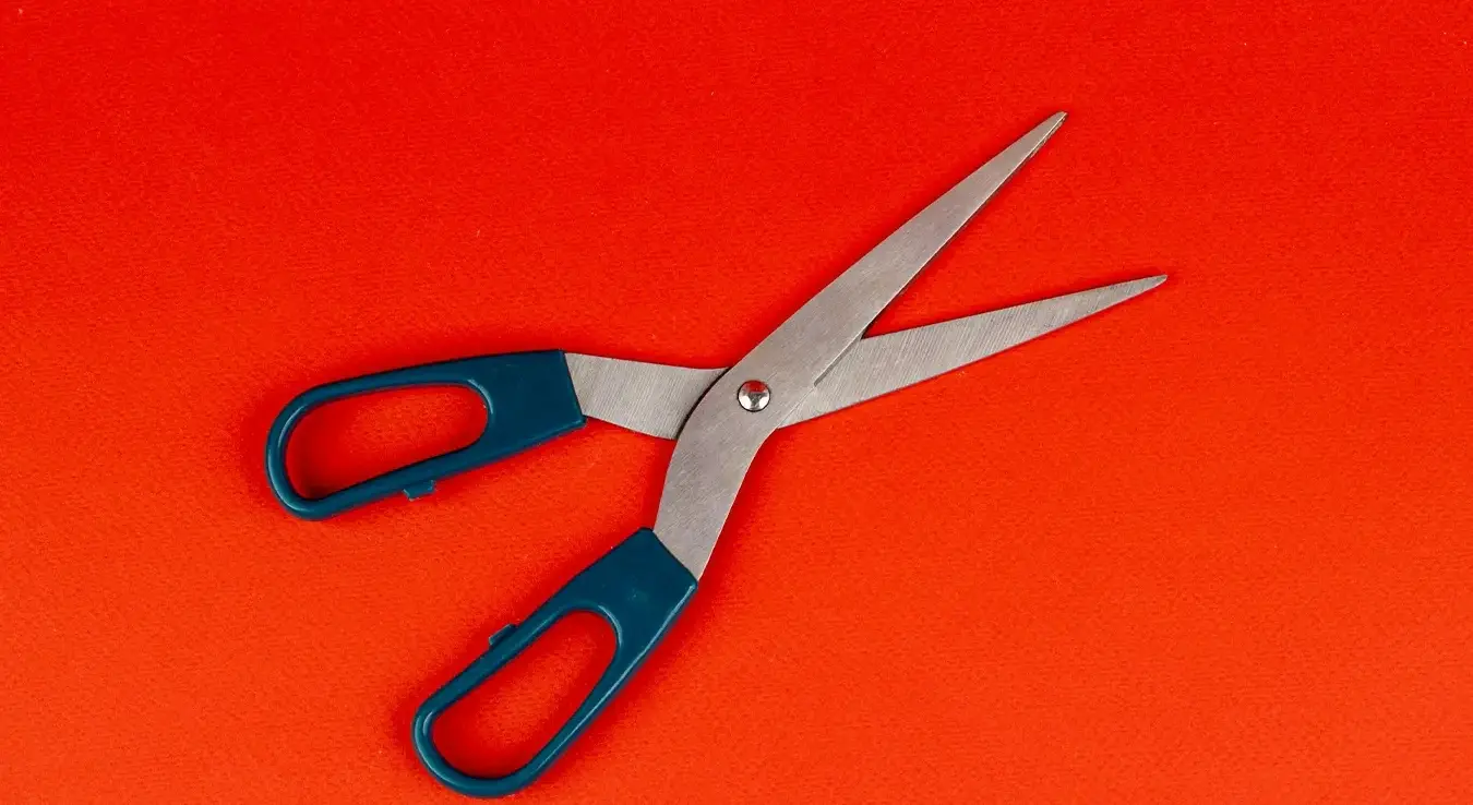 Маказе на наранџастој подлози.