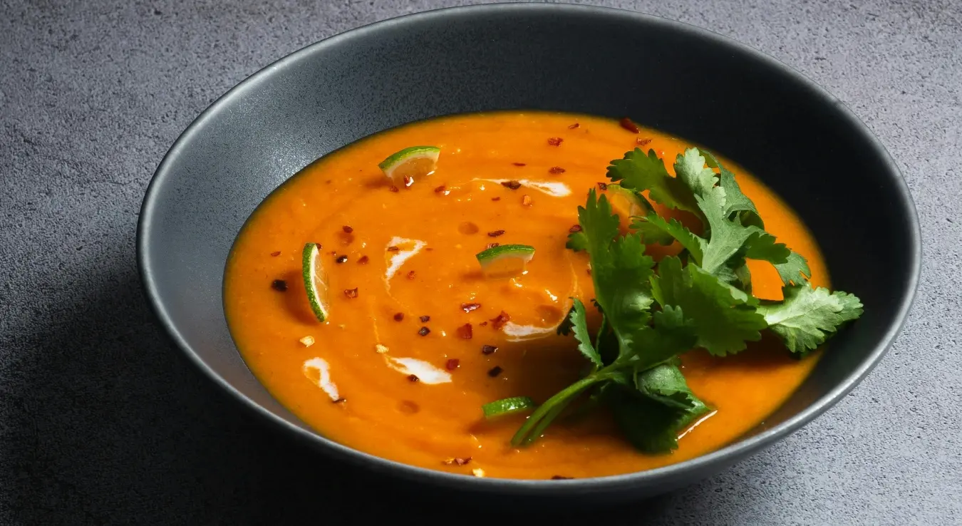 Супа од тиквица у тамно сивој здјели са листом першуна