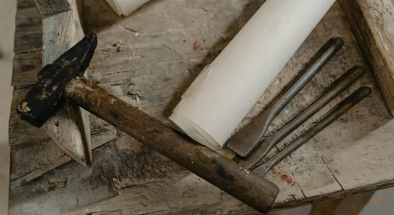 Чекић на столу поред осталог алата.