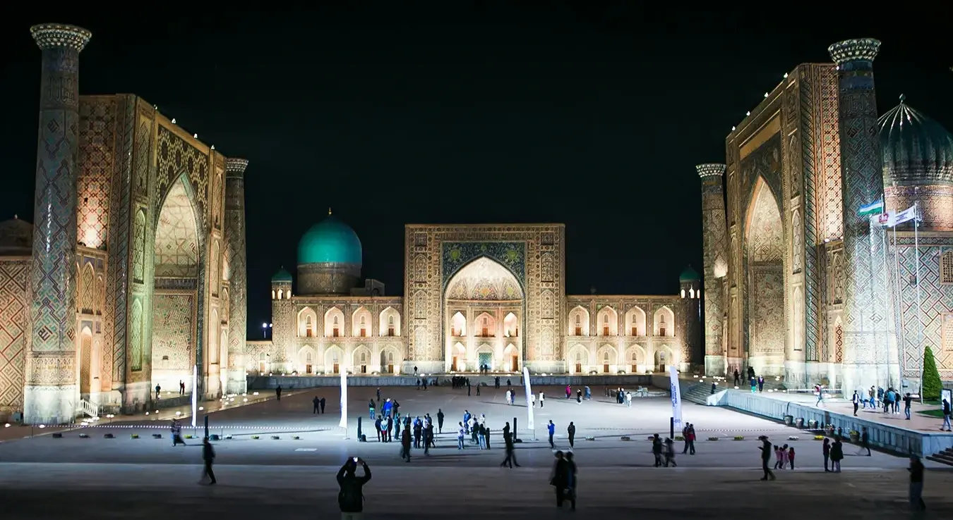 Људи шетају око чувеног Регистана у Самарканду током ноћи.