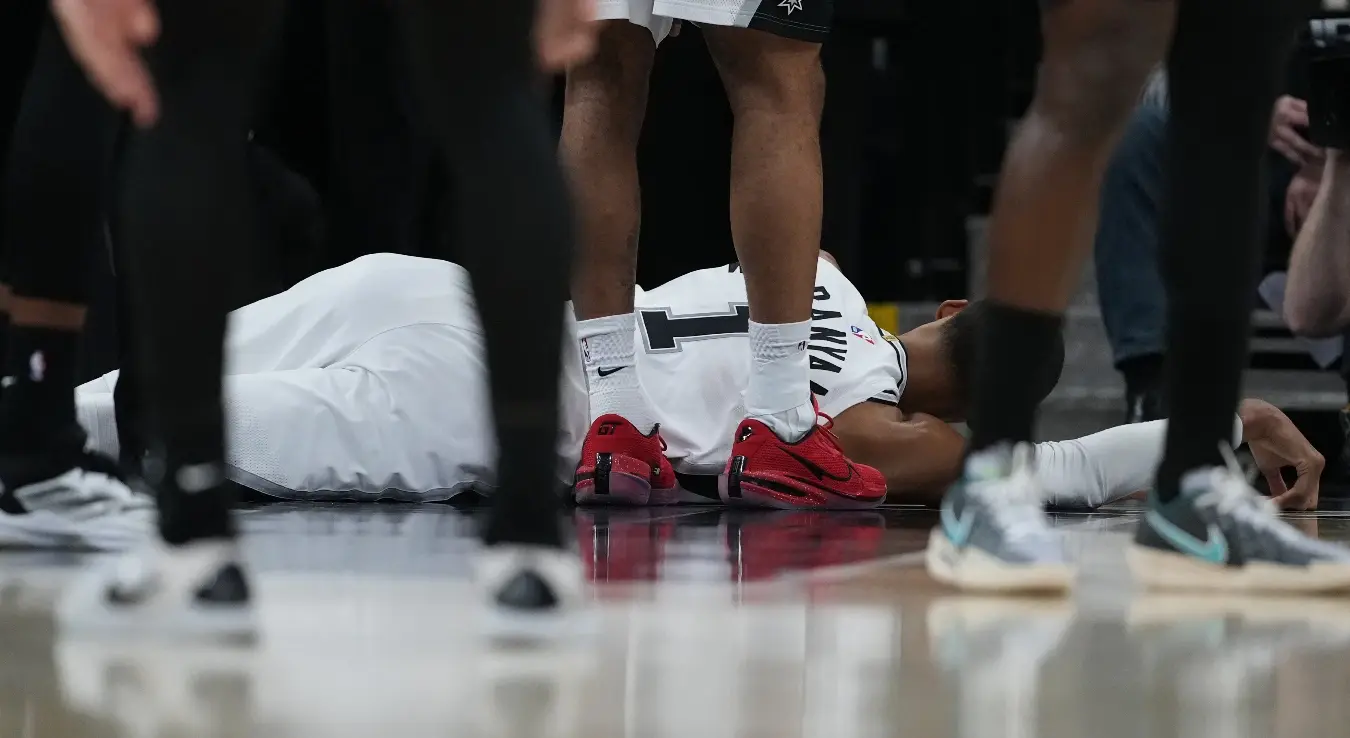 Виктор Вембањама лежи на паркету након што је ударио главом о под на мечу против Портланда