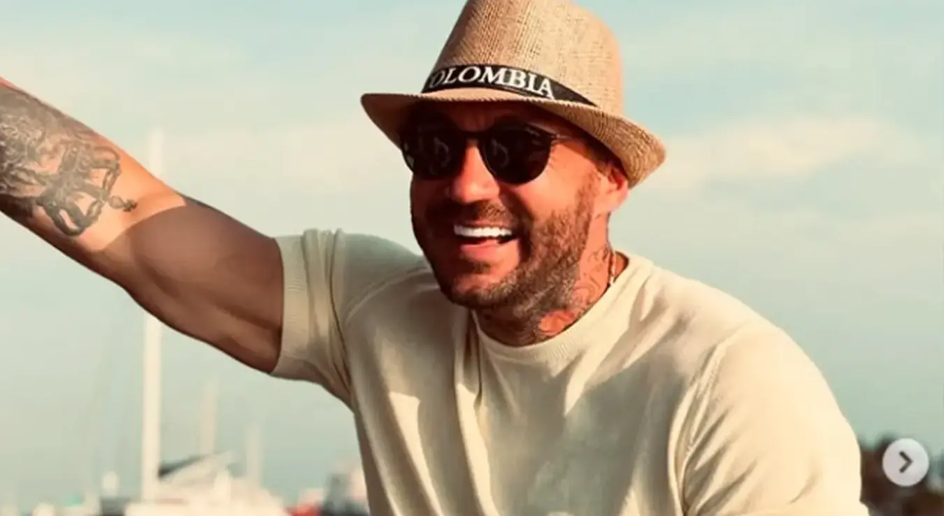 Јован Радуловић Јоџир са шеширом сједи и подиже руку.