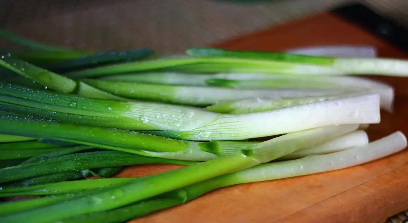 Млади лук очишћен и опран стоји на столу