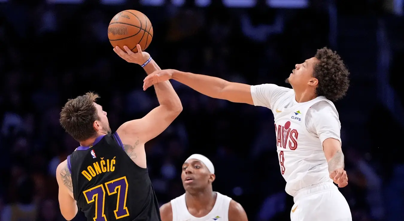 Бек Лос Анђелес Лејкерса Лука Дончић, лијево, шутира док бек Кливленд Кавалирса Крејг Портер млађи брани током другог полувремена НБА кошаркашке утакмице у уторак, 31. марта 2026. године, у Лос Анђелесу.