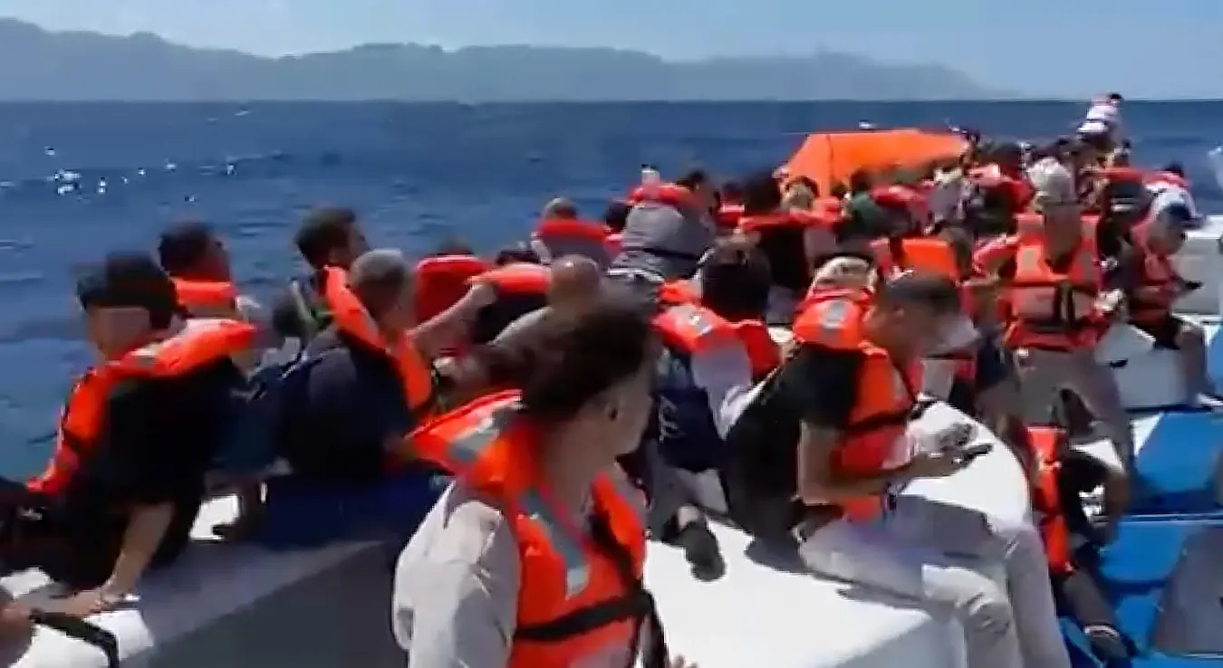 На овом кадру из видеа, путници у прслуцима за спасавање чекају спасавање на преврнутом путничком броду код обале Гирне, у сјеверном дијелу Кипра под турском окупацијом, у недјељу, 30. августа 2026. године.