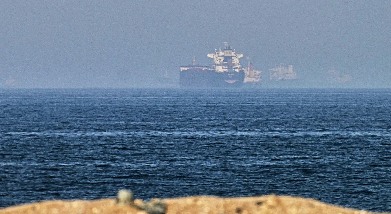 Теретни бродови плове морем у близини Ормуског мореуза, посматрано са камените обале код Хор Факана, у Уједињеним Арапским Емиратима, у петак, 1. маја 2026. године.