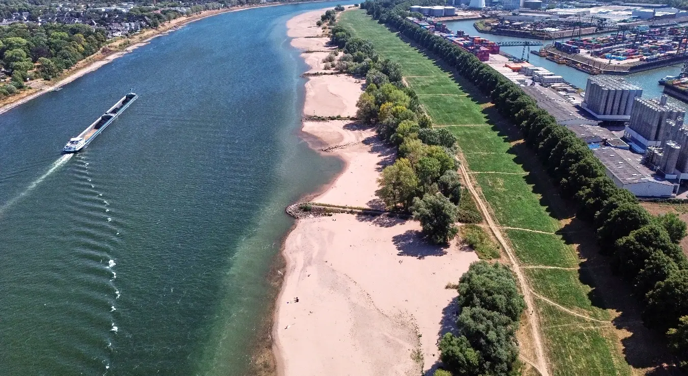 Теретни бродови плове поред пјешчаних спрудова при ниском водостају на ријеци Рајни поред луке Келн-Нил у Келну, Њемачка, понедјељак, 10. августа 2026.