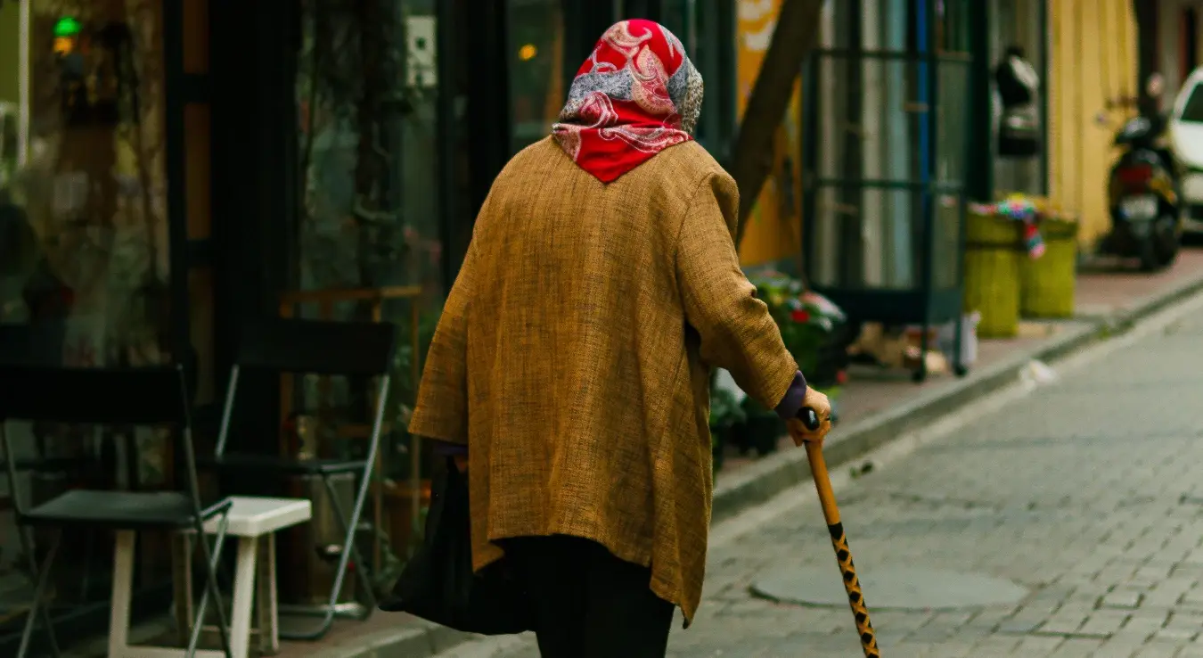 Старица са штапом хода тихим сокаком, будећи носталгију.